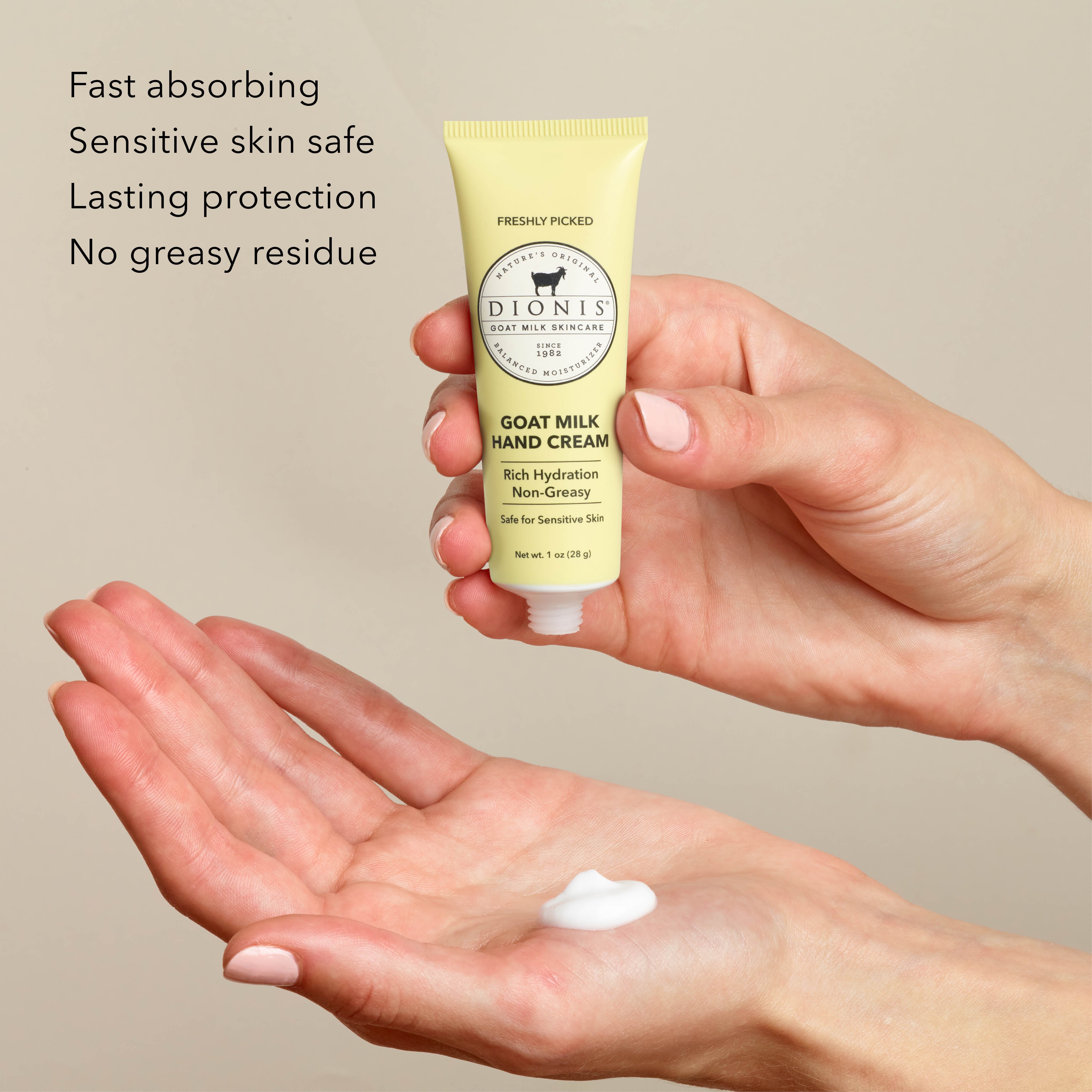 A person holds a tube of Dionis Goat Milk Hand Cream in Freshly Picked above an open palm with a dollop of white cream, with marketing text on the left against a warm beige background.