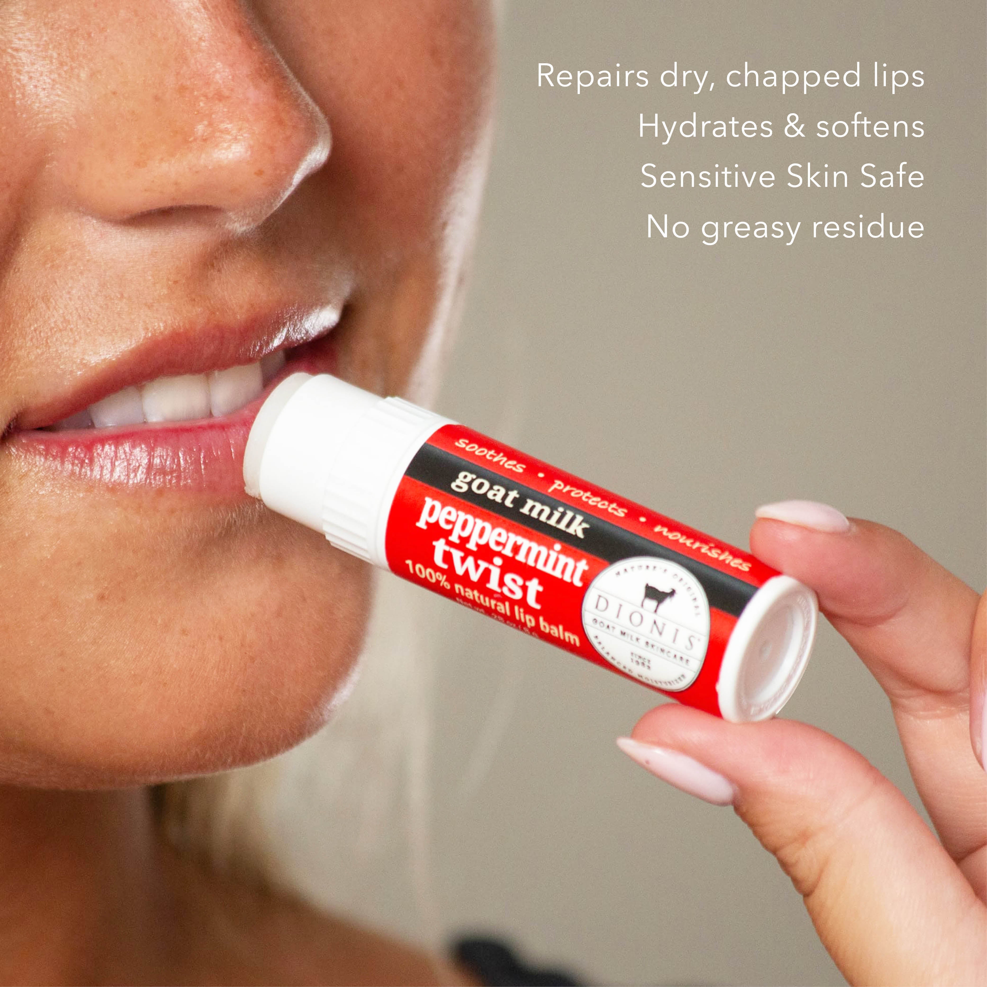 Person applying a red and white lip balm stick labeled 'peppermint twist' to their lips.