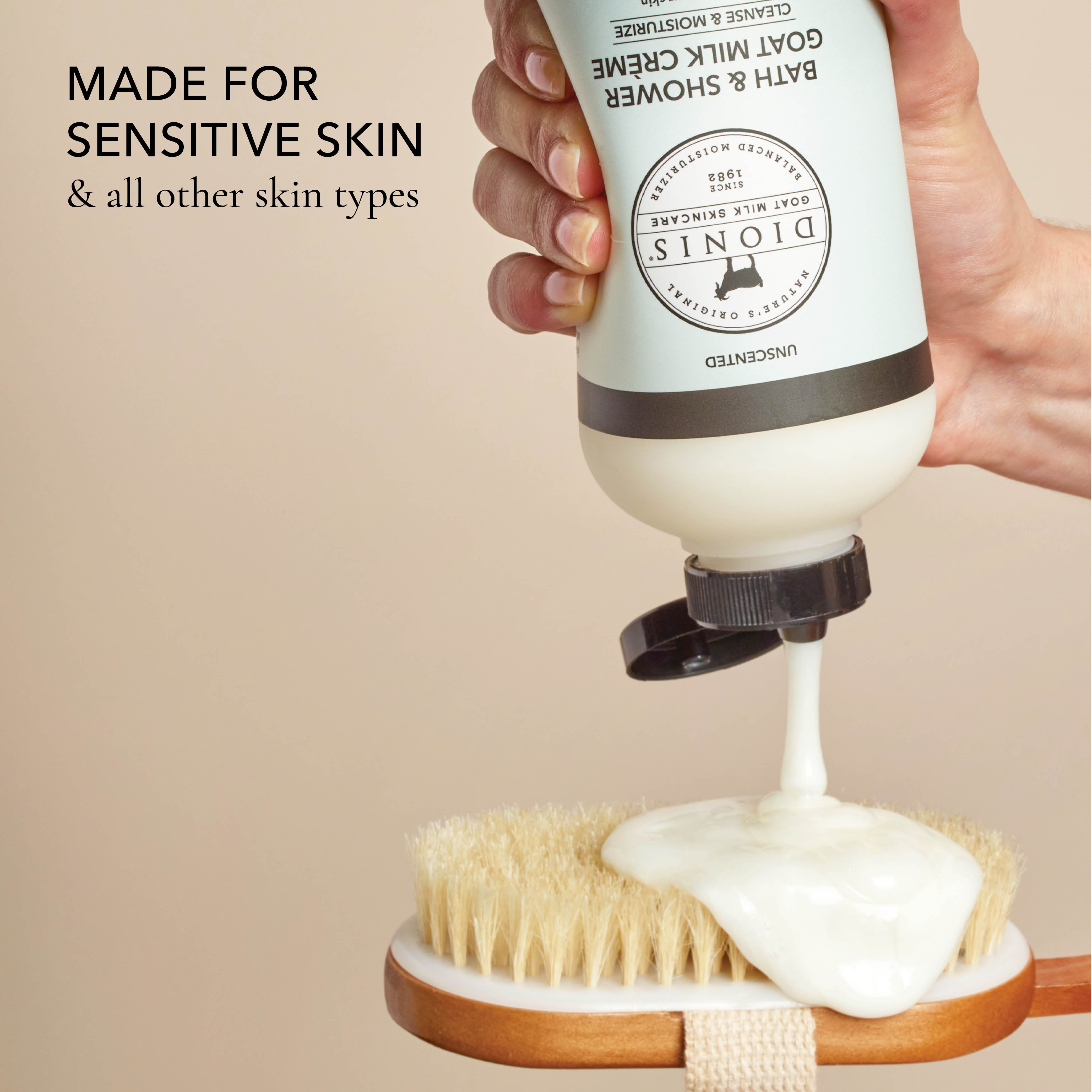 Hand holding a bottle of the shower creme and squeezing it out onto a wash brush, with the text that says "made for sensitive skin & all other skin types", all on a beige background.