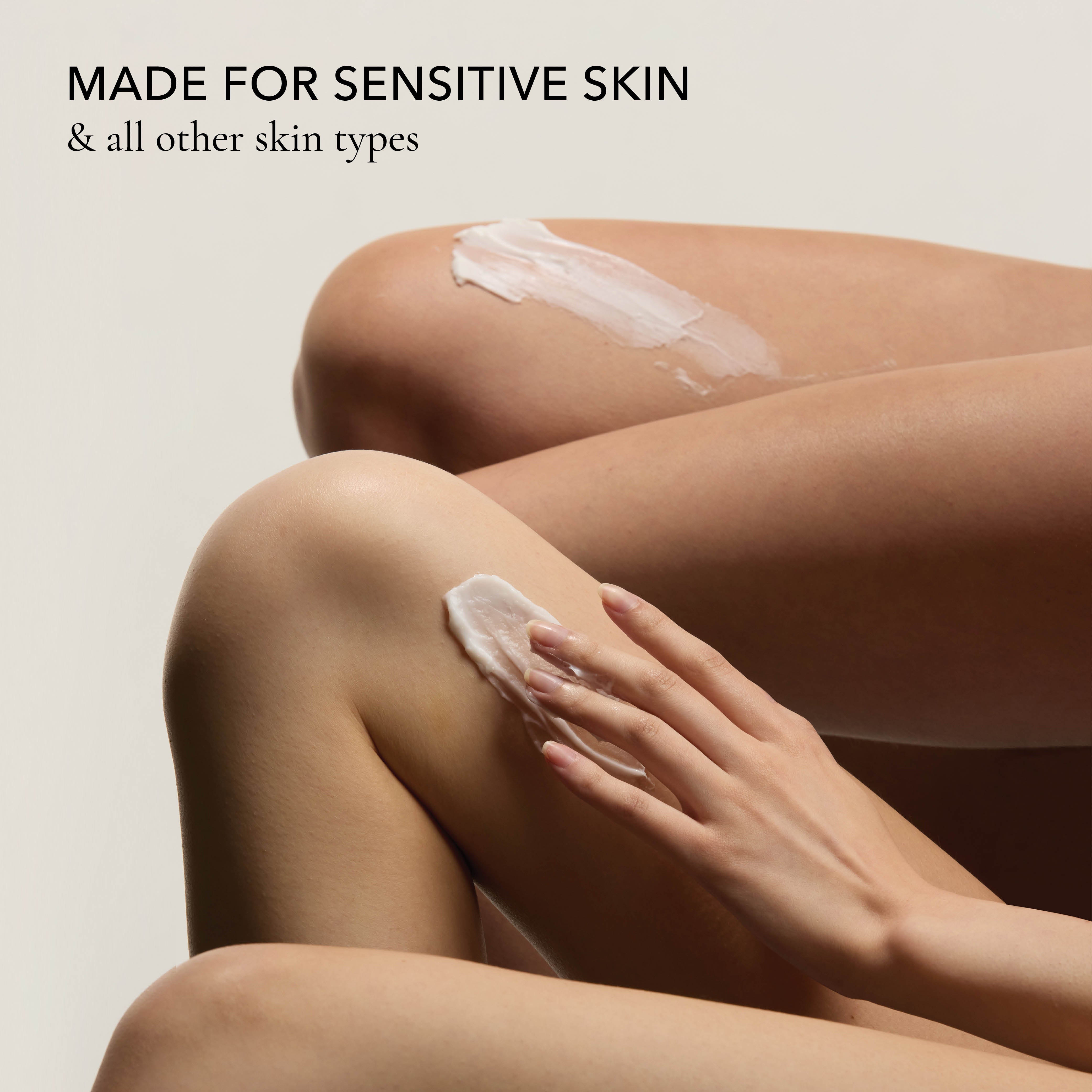 Close up of model applying Dionis Goat Milk Body Scrub to the skin on her legs.
Text reads: Made for Sensitive Skin & all other skin types.