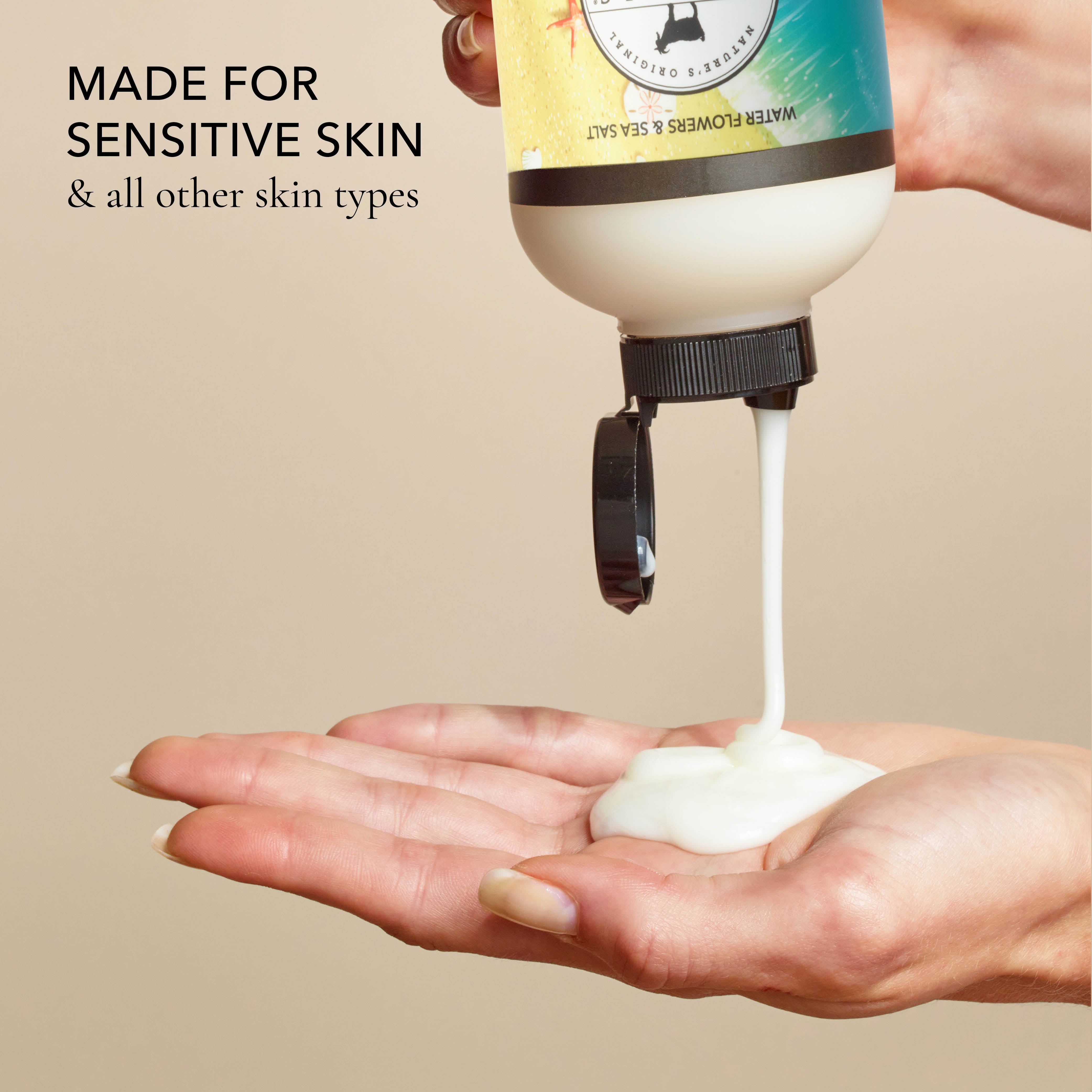 Hand holding a bottle of the shower creme and squeezing it out into the other hand, with the text that says "made for sensitive skin & all other skin types", all on a beige background.
