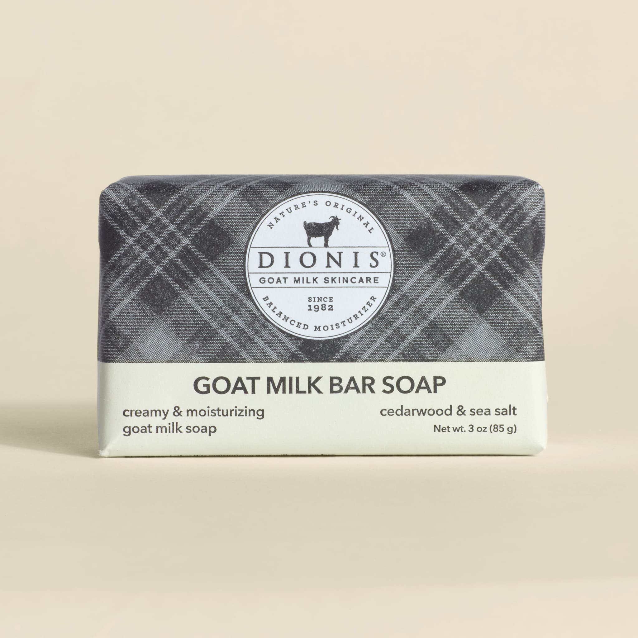 Bar of goat milk soap with plaid wrapper on a beige background
