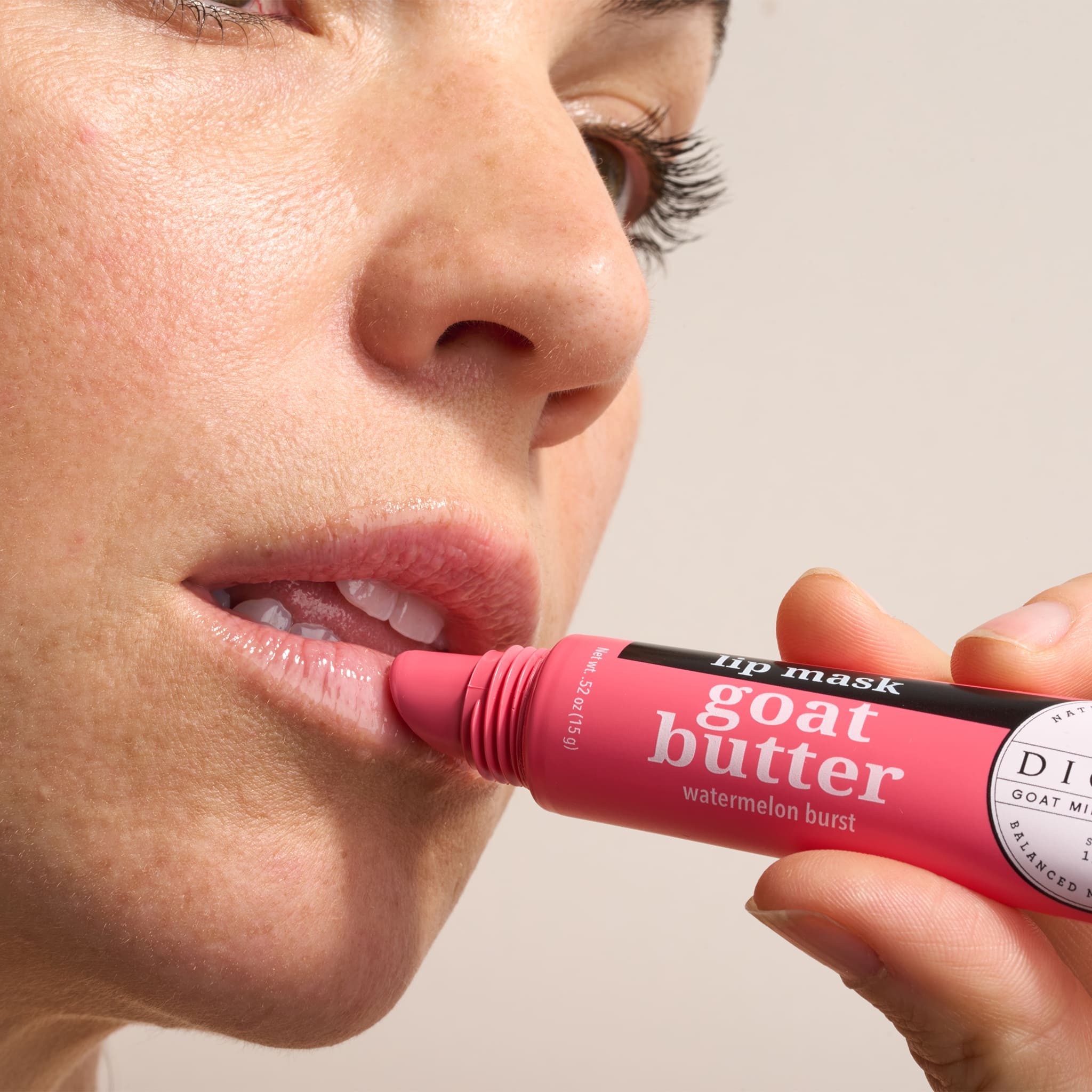 Person applying a pink Dionis Watermelon Goat Butter Lip Mask to her lips