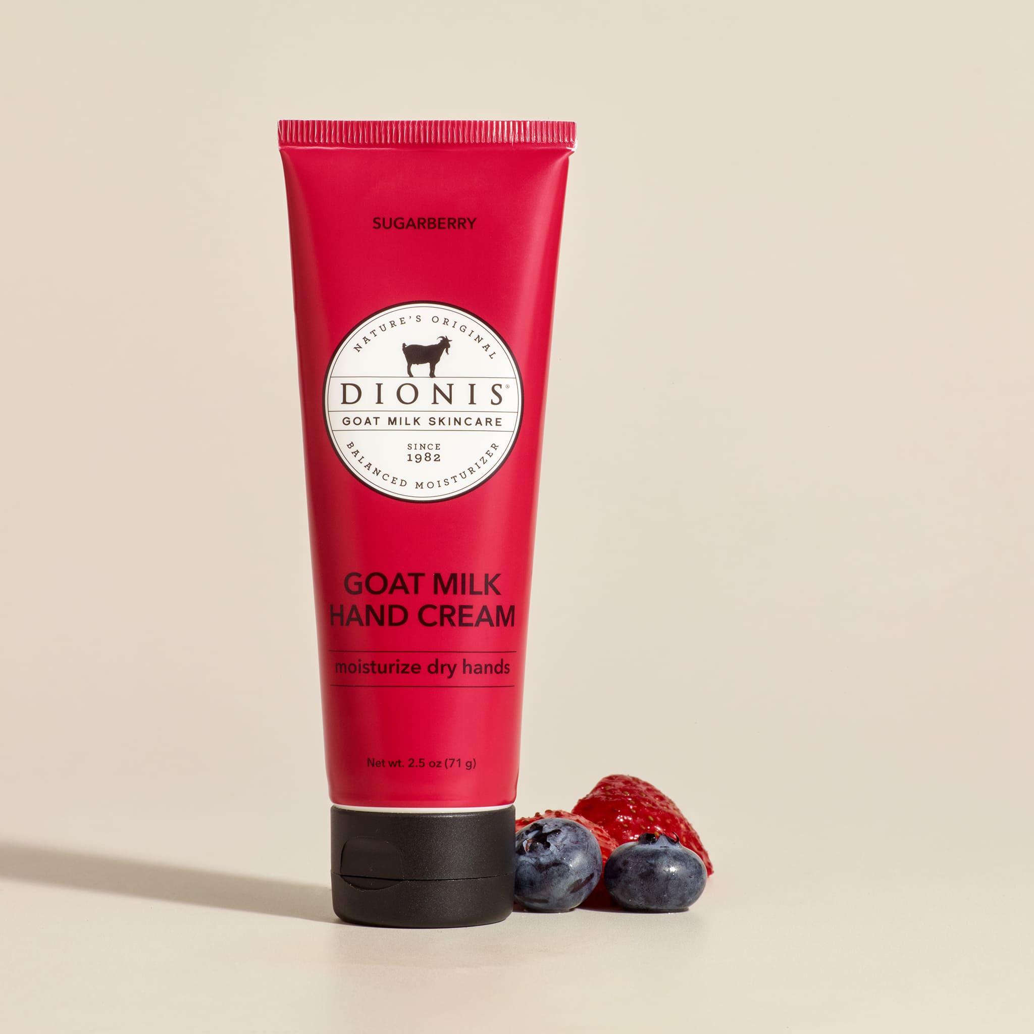 Sugarberry 2.5 oz goat milk hand cream with berries next to it on a beige background