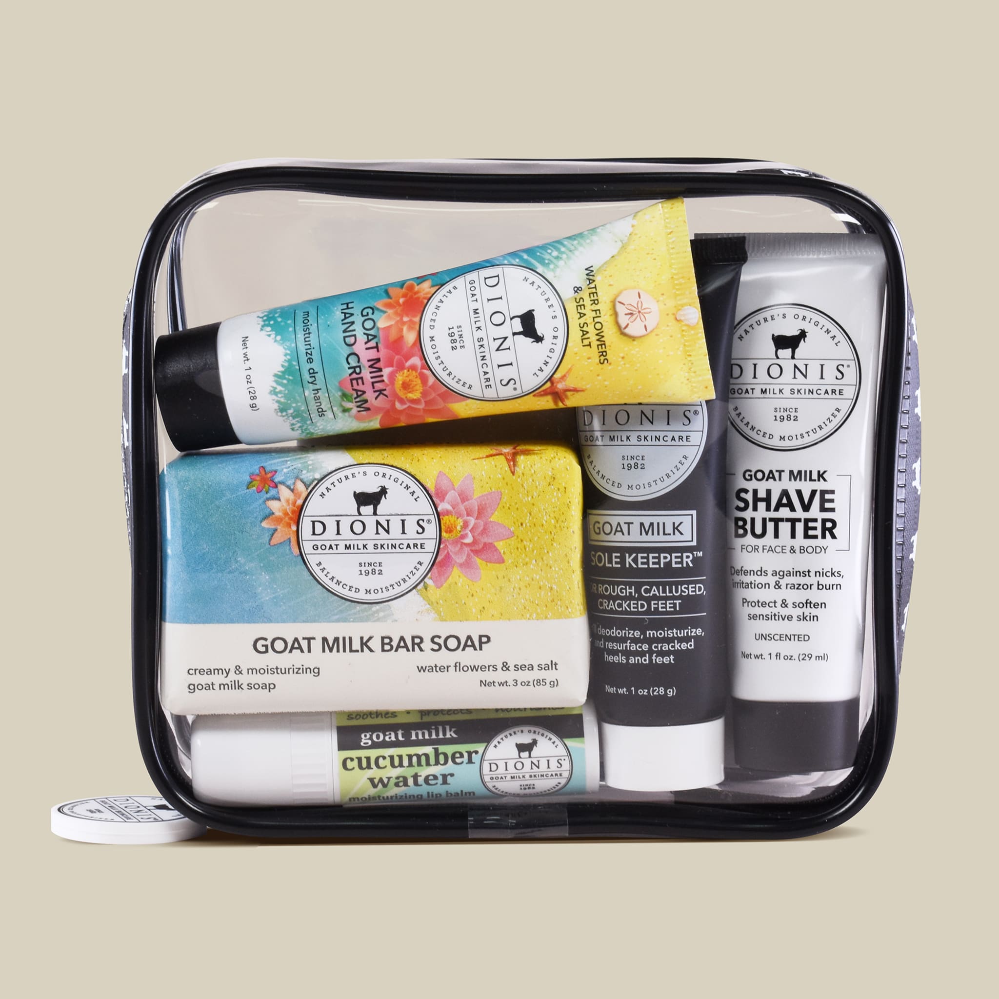 Set of Dionis goat milk skincare products in a clear travel case on a beige background