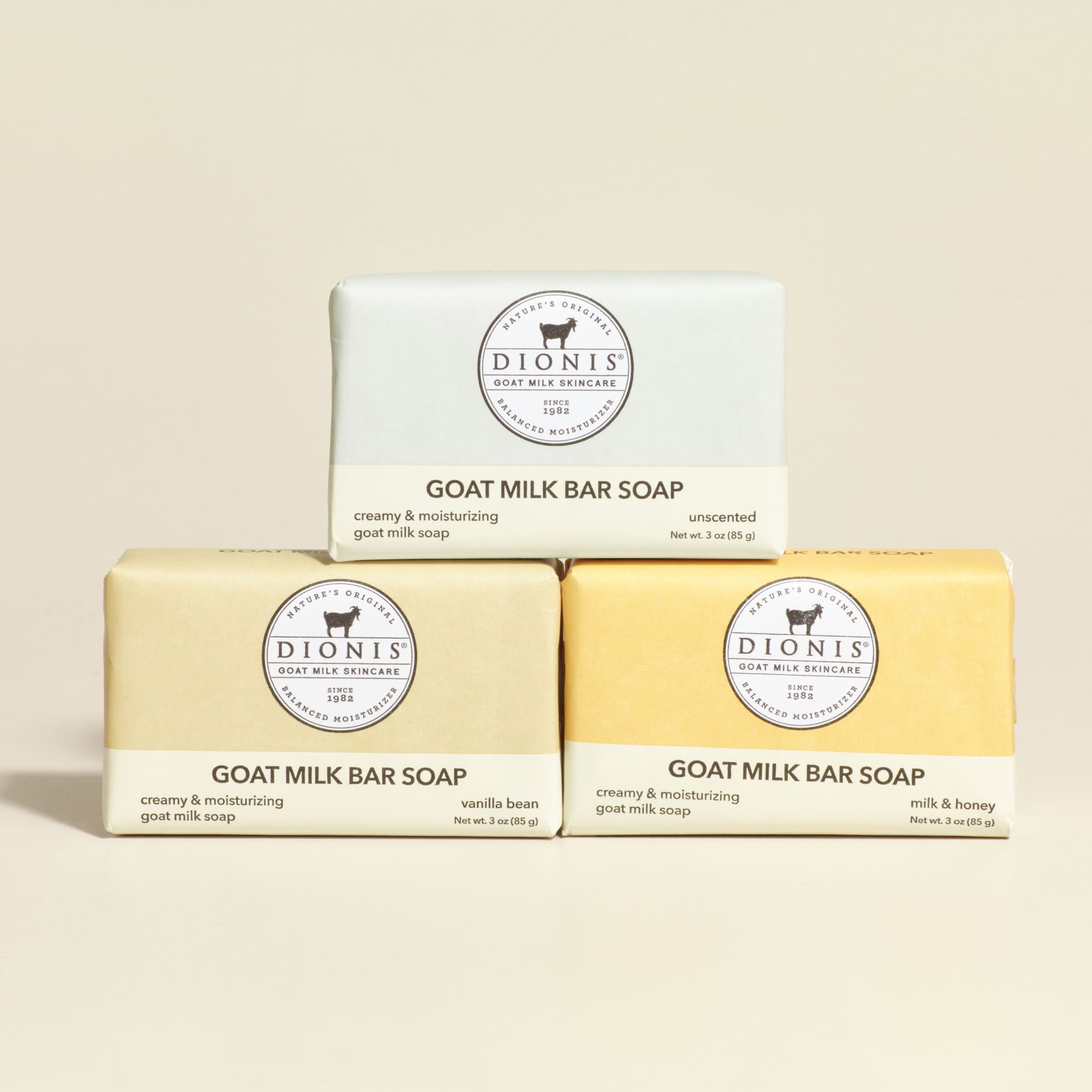 Three bars of Dionis goat milk bar soap on a beige background