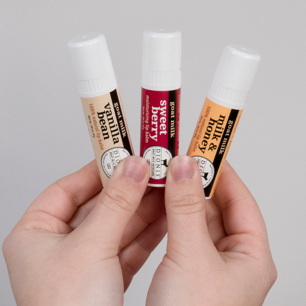 Two hands holding 3 different lip balm flavors