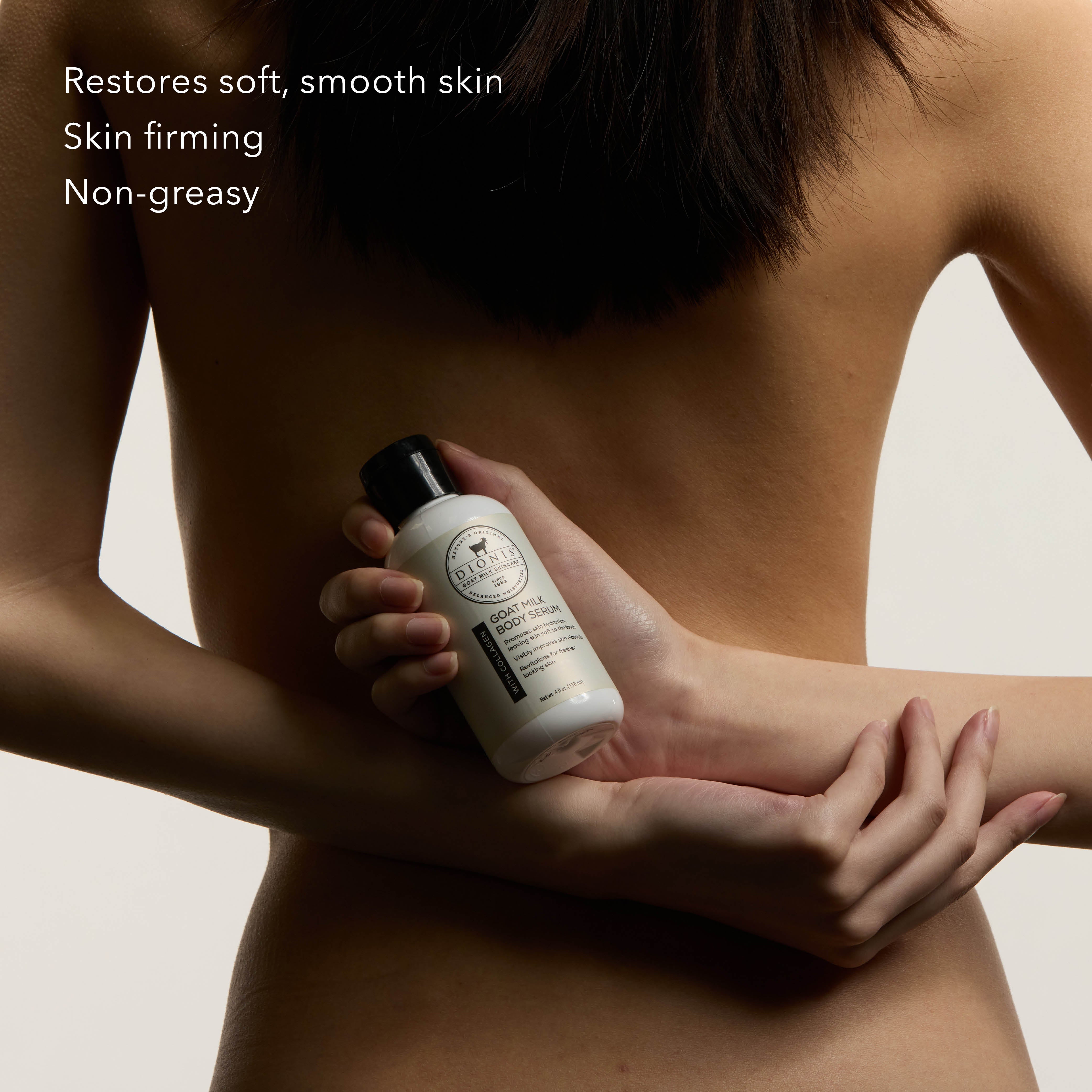 A woman from behind holds a bottle of Dionis Goat Milk Body Serum with Collagen against her back. The image features white text on the top left listing benefits: 'Restores soft, smooth skin', 'Skin firming', and 'Non-greasy'.