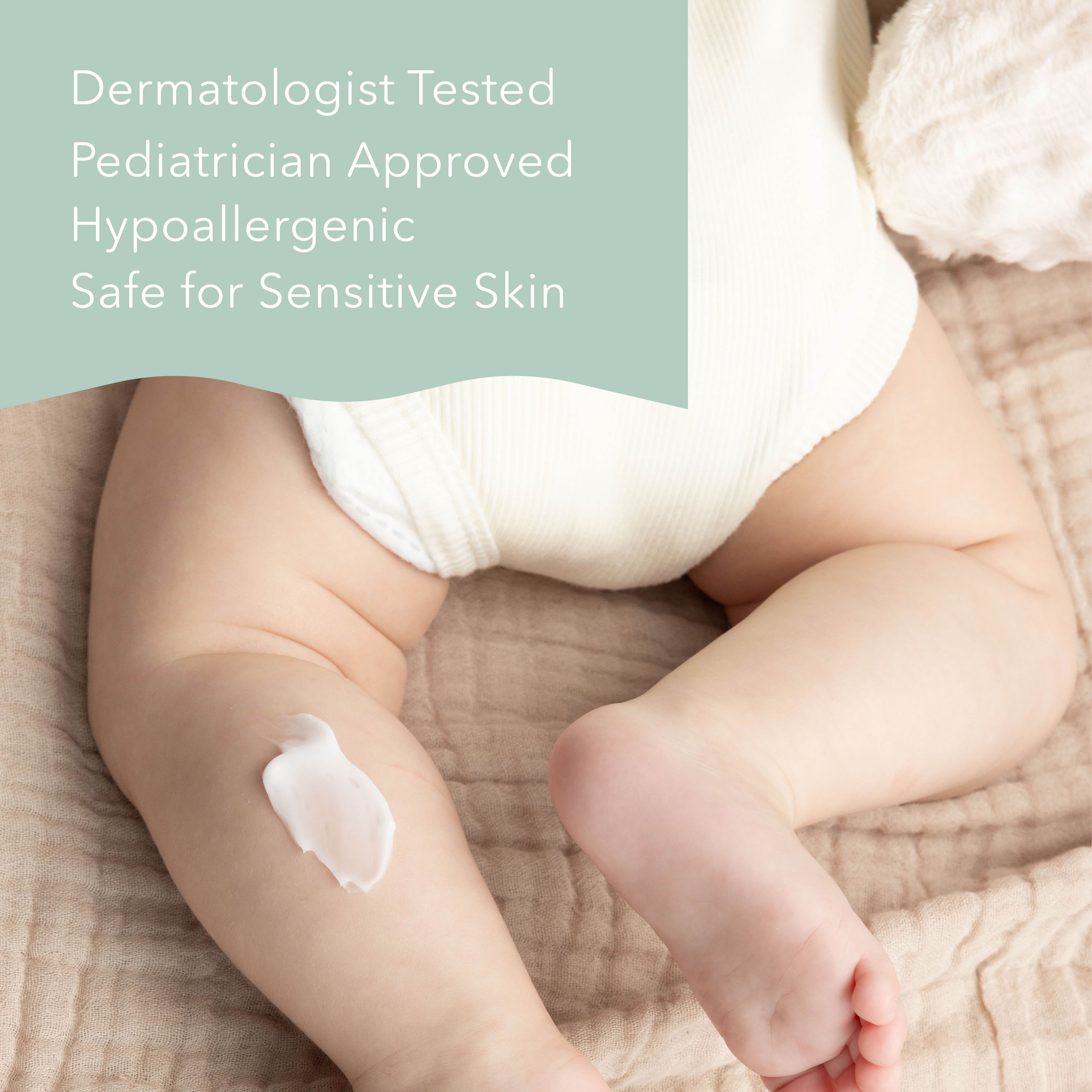 A baby wearing a white ribbed diaper sits on a beige textured blanket, with a dollop of white cream on the baby's leg. A sage green text banner in the top left reads: 'Dermatologist Tested Pediatrician Approved Hypoallergenic Safe for Sensitive Skin'.
