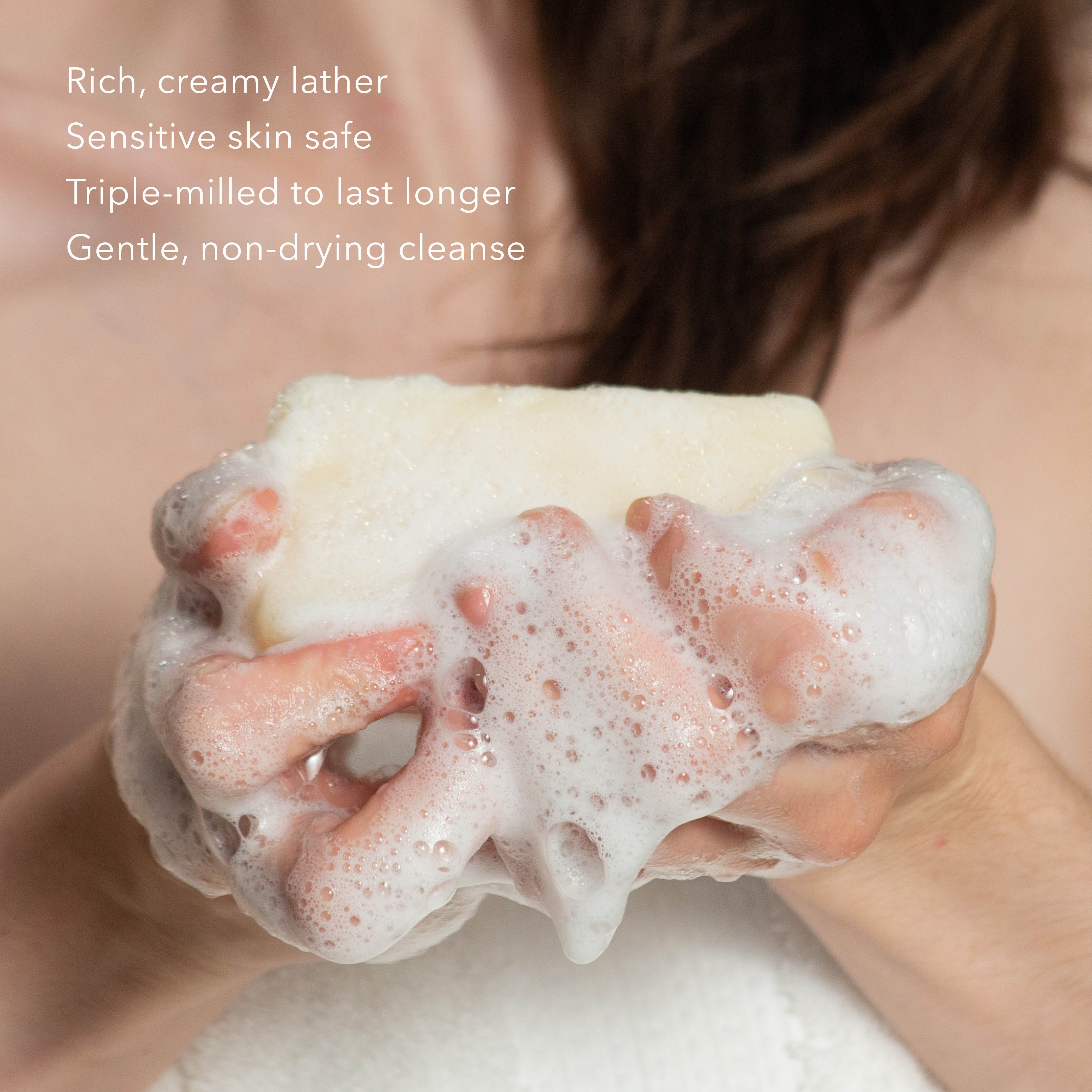 Woman holding sudsy Dionis Goat Milk Bar Soap in both hands