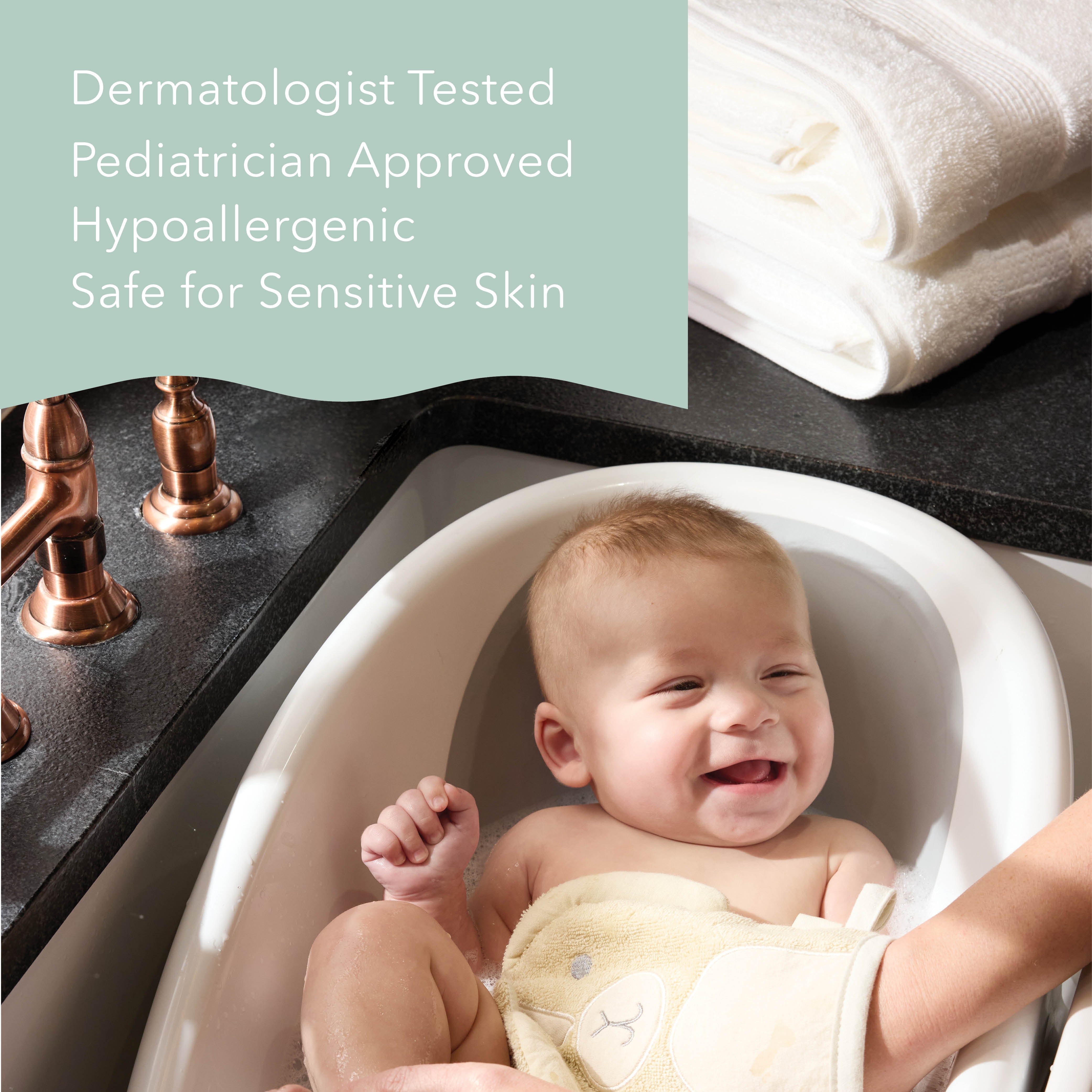 A baby sitting in a white bathtub holding a beige towel, with a folded white towel and copper faucet in the background. Text on the left reads: 'Dermatologist Tested Pediatrician Approved Hypoallergenic Safe for Sensitive Skin'.