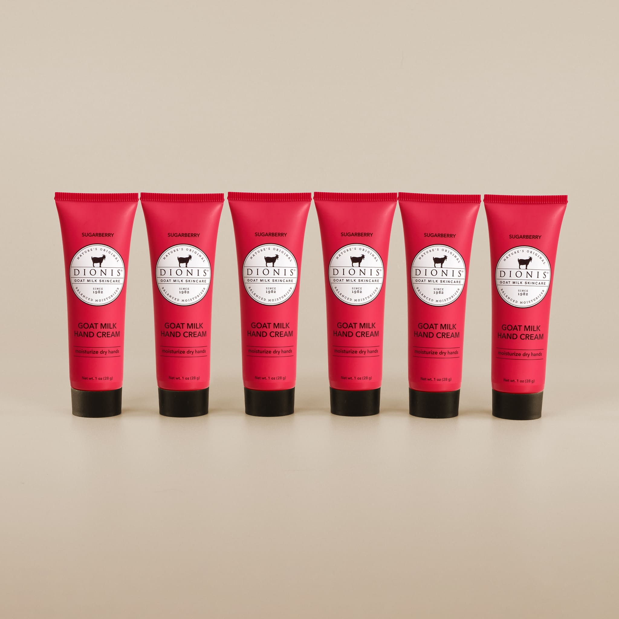 6 tubes of sugarberry hand cream in a row against a beige background