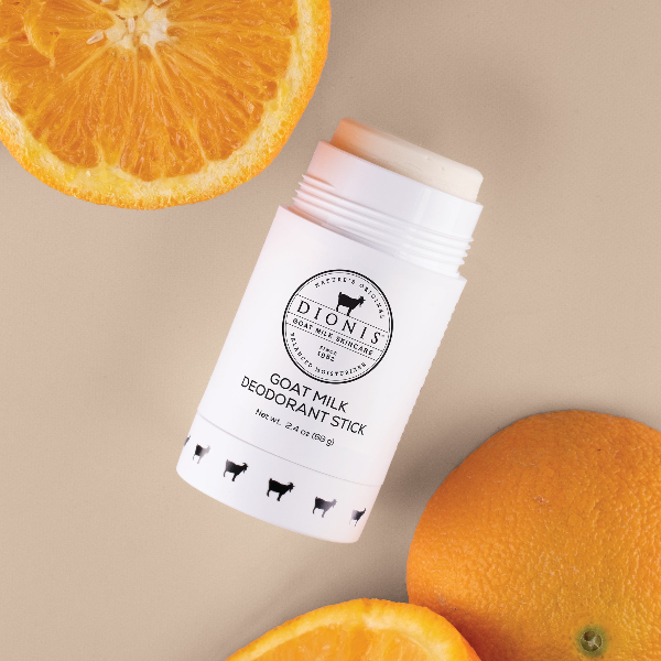 Dionis Goat Milk Deodorant Stick with oranges as props around it.