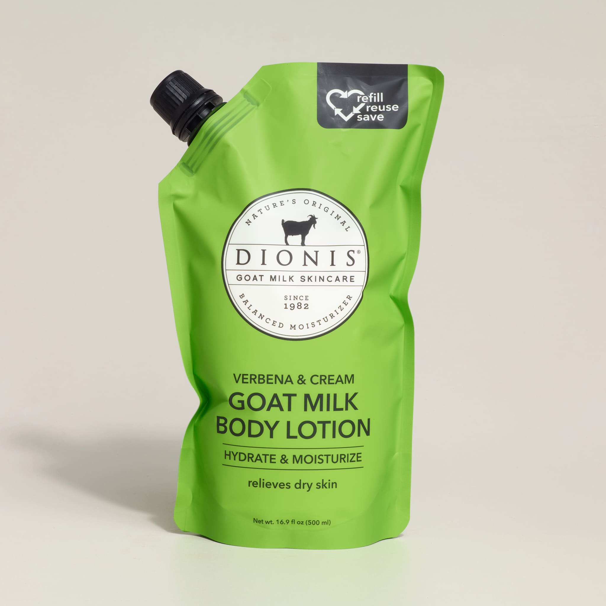 Green bottle of Dionis goat milk body lotion on a light gray background