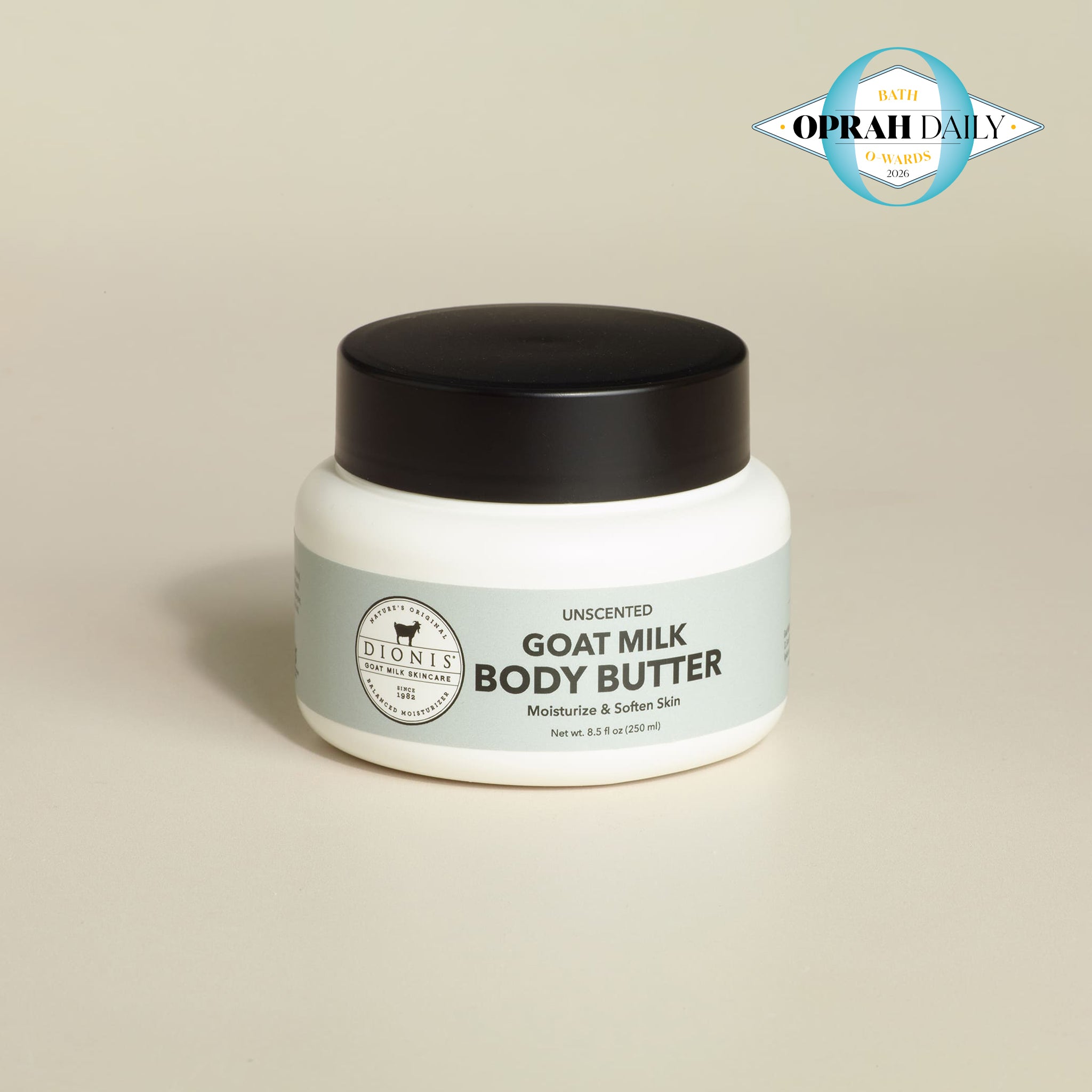 Jar of goat milk body butter with a black lid on a beige background