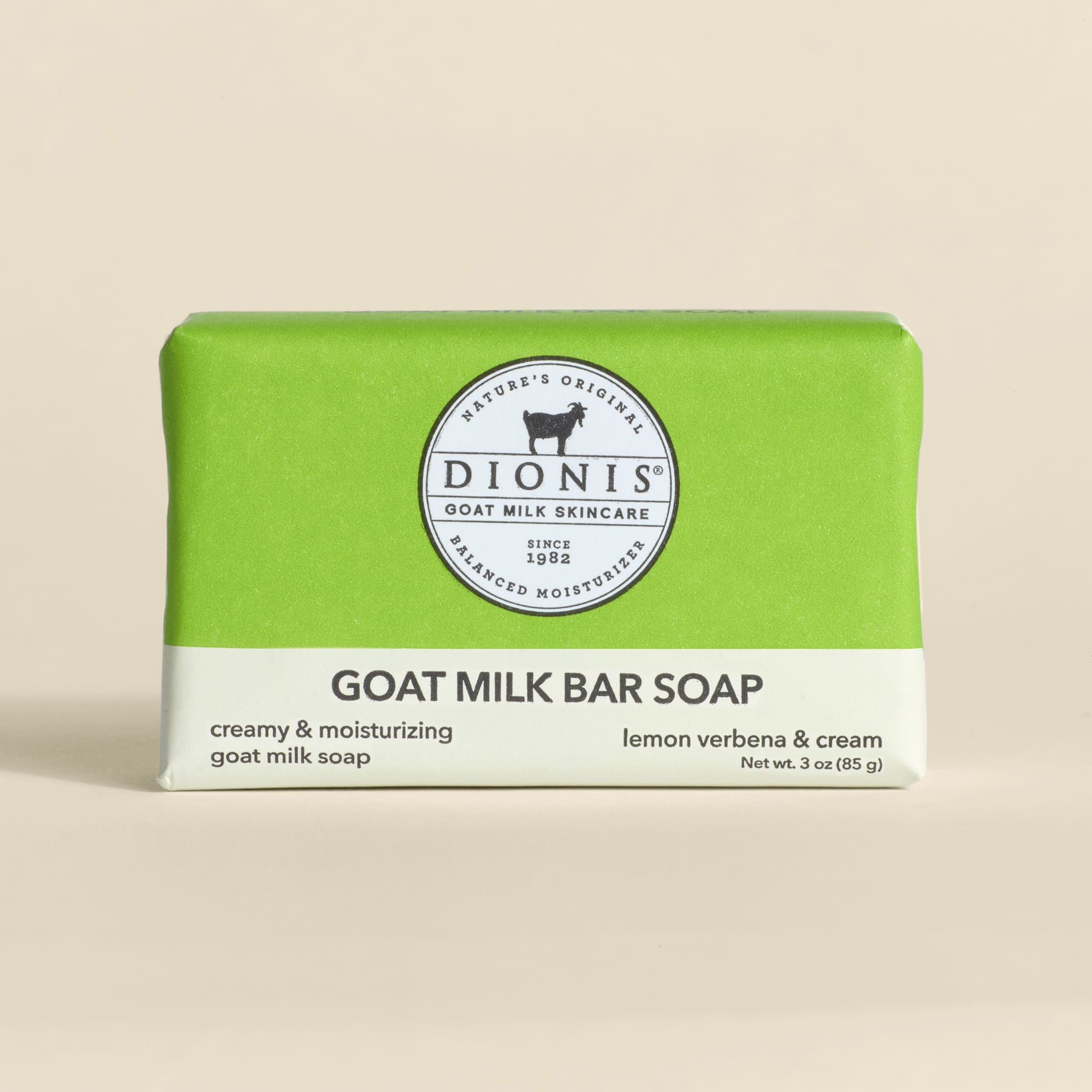 Bar of goat milk soap with green and white packaging on a beige background