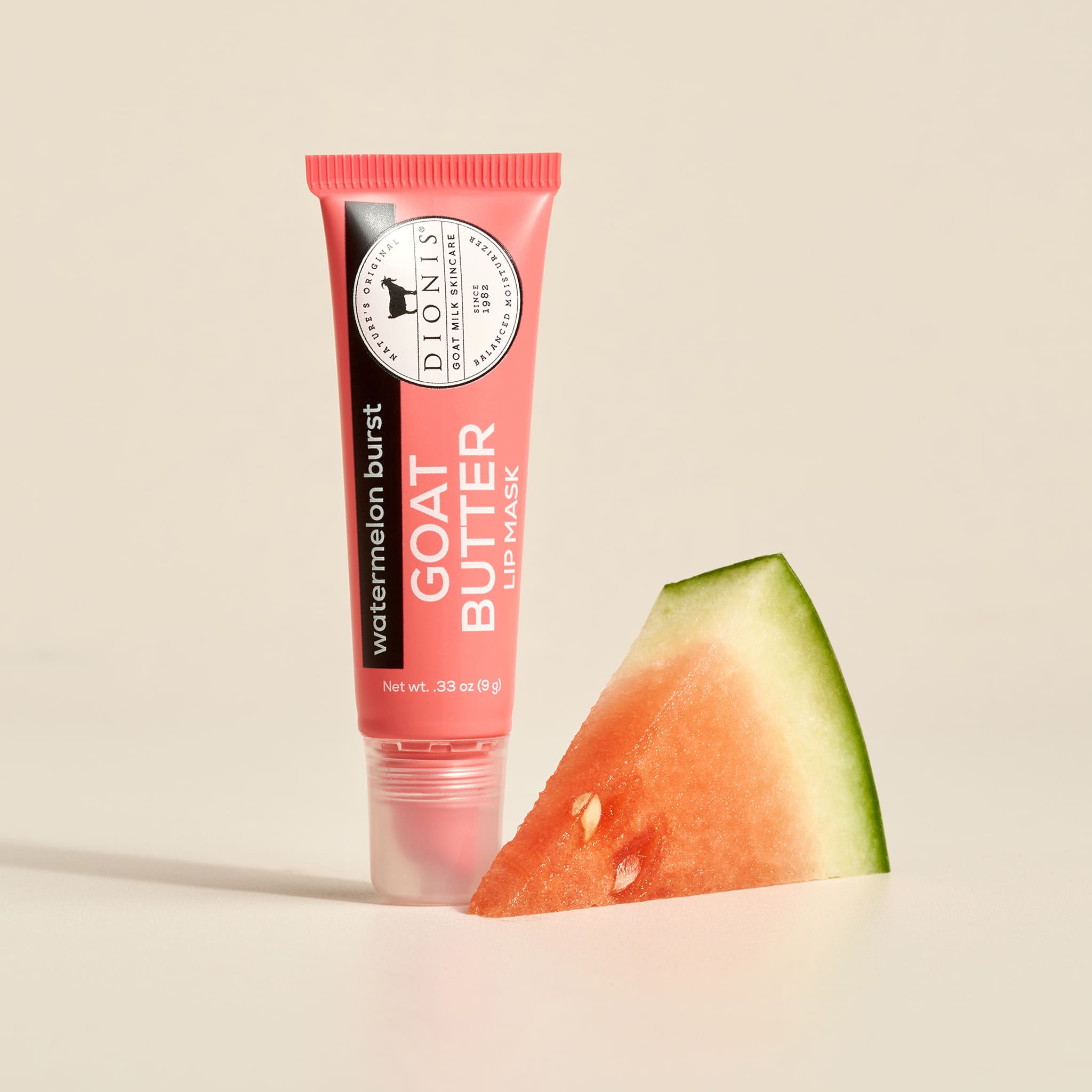 Tube of Dionis watermelon burst goat butter lip mask with a slice of watermelon on a beige background