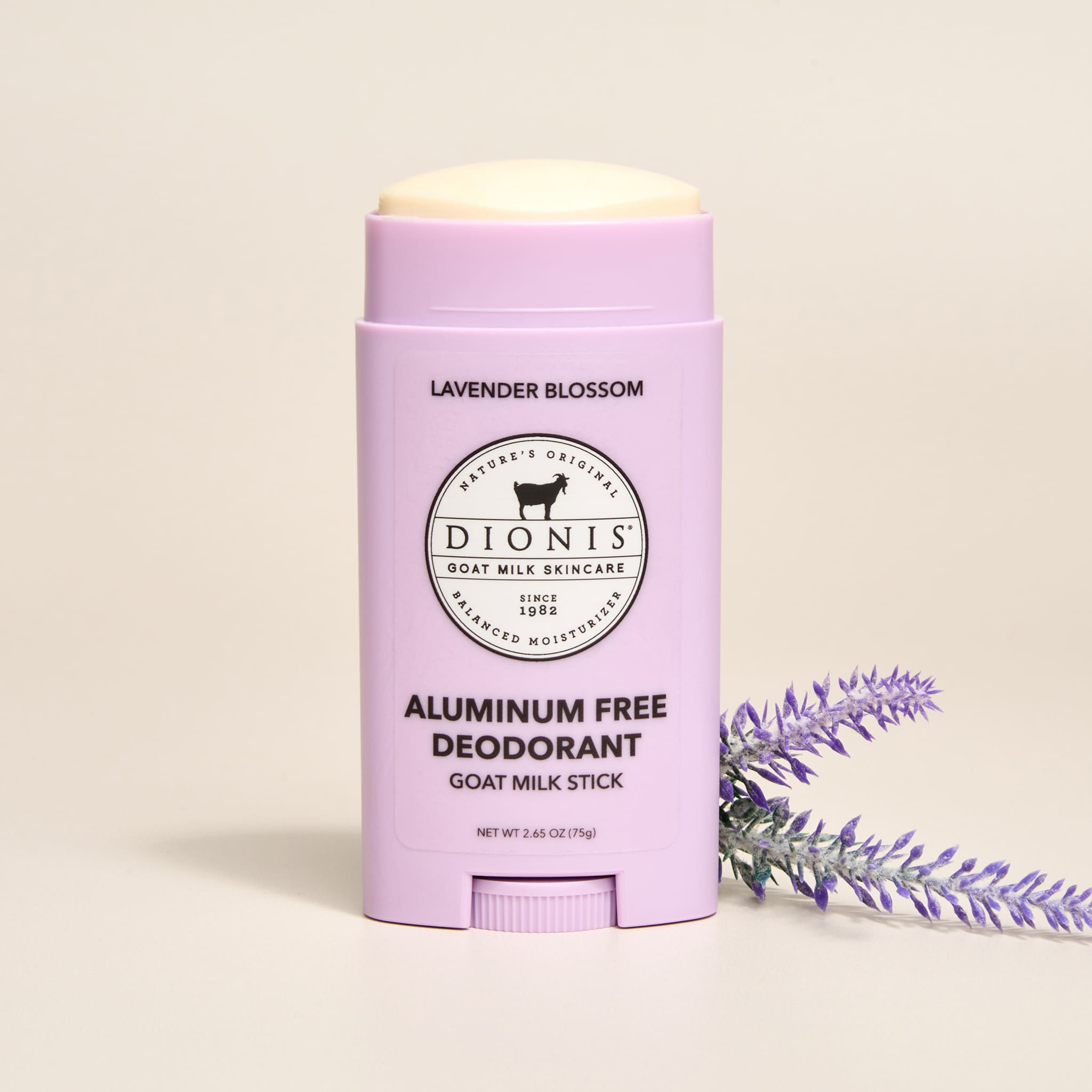 Dionis Lavender Blossom Goat Milk Aluminum Free Deodorant Stick with lavender sprigs on a beige background