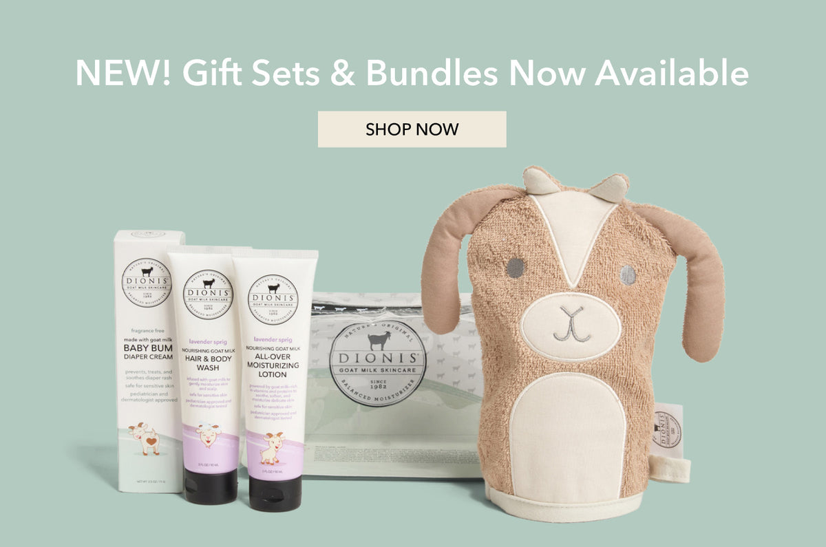 A baby gift set bundle from Dionis on a sage green background, featuring three tubes of baby care products and a plush tan and cream goat-shaped bath mitt. White text at the top reads 'NEW! Gift Sets & Bundles Now Available' with a 'SHOP NOW' button above.