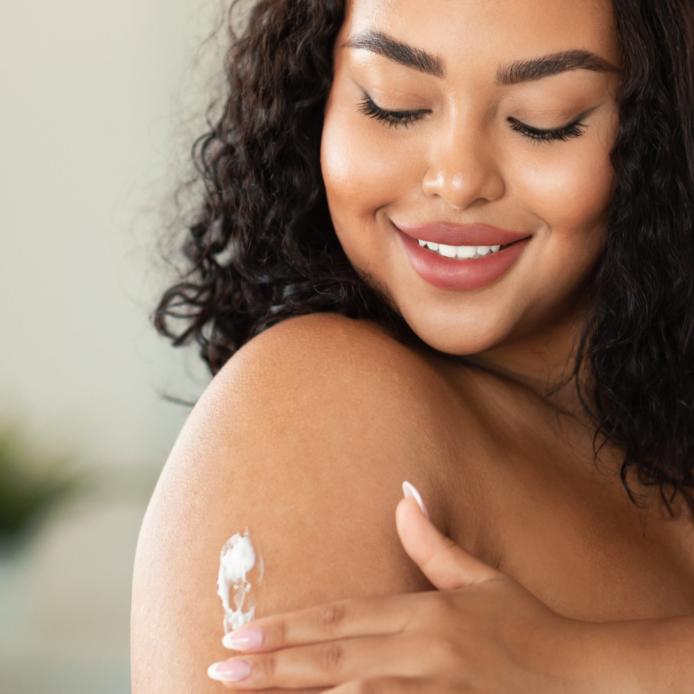 model applying lotion to arm and shoulder area