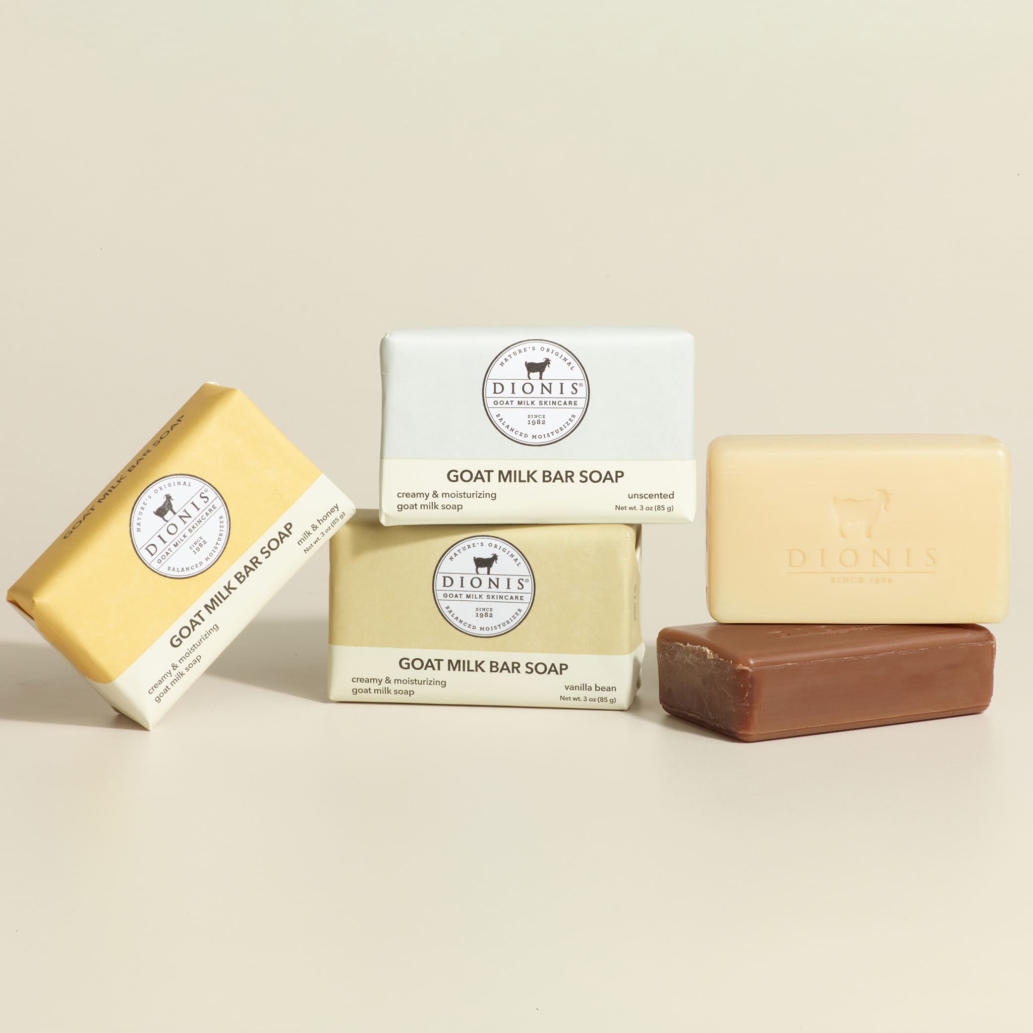 Three bars of Dionis goat milk bar soap on a beige background