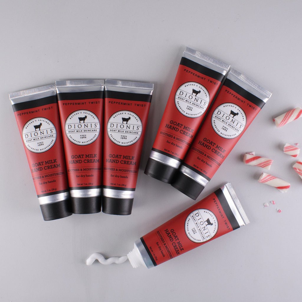 6 Peppermint Twist goat milk hand creams lying flat on surface, with pieces of candy cane