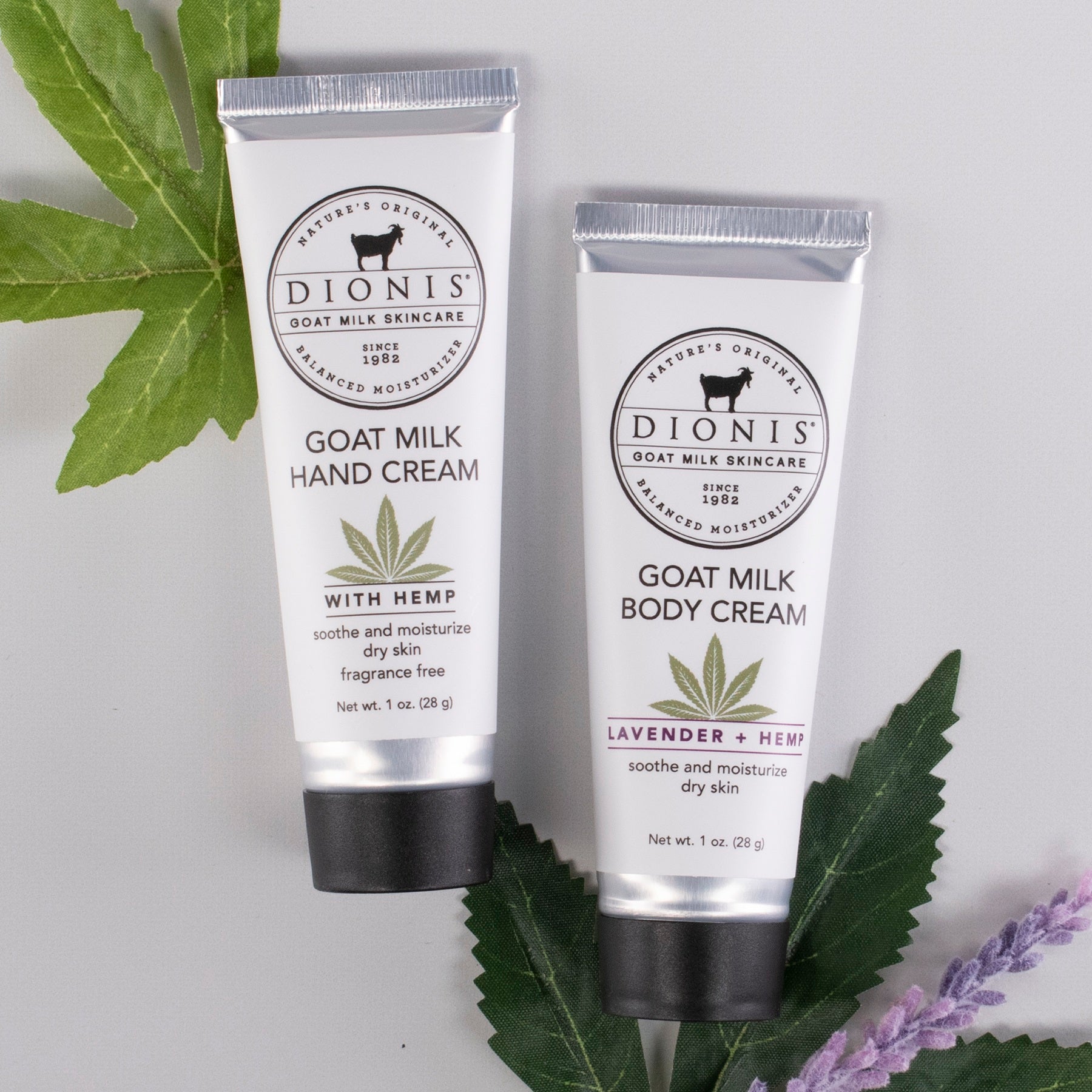 Two tubes of Dionis goat milk skincare products made with hemp, with leaves and lavender on a light gray background